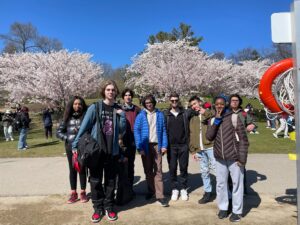 A group of students standing in front of blooming cherry blossoms in High Park, Toronto.