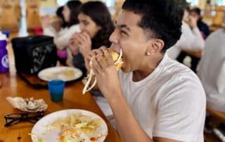 sep2026-camp-07 A student enjoying a meal in the dining hall