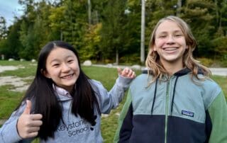 sep2026-camp-09 Two students smiling and giving a thumbs up