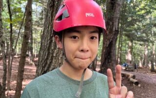 sep2026-camp-15 A student in a red helmet making a peace sign