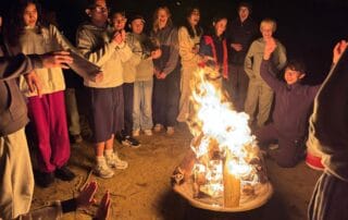 sep2026-camp-23 Students around the campfire at night