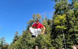 sep2026-camp-26 A student on the zipline against a blue sky
