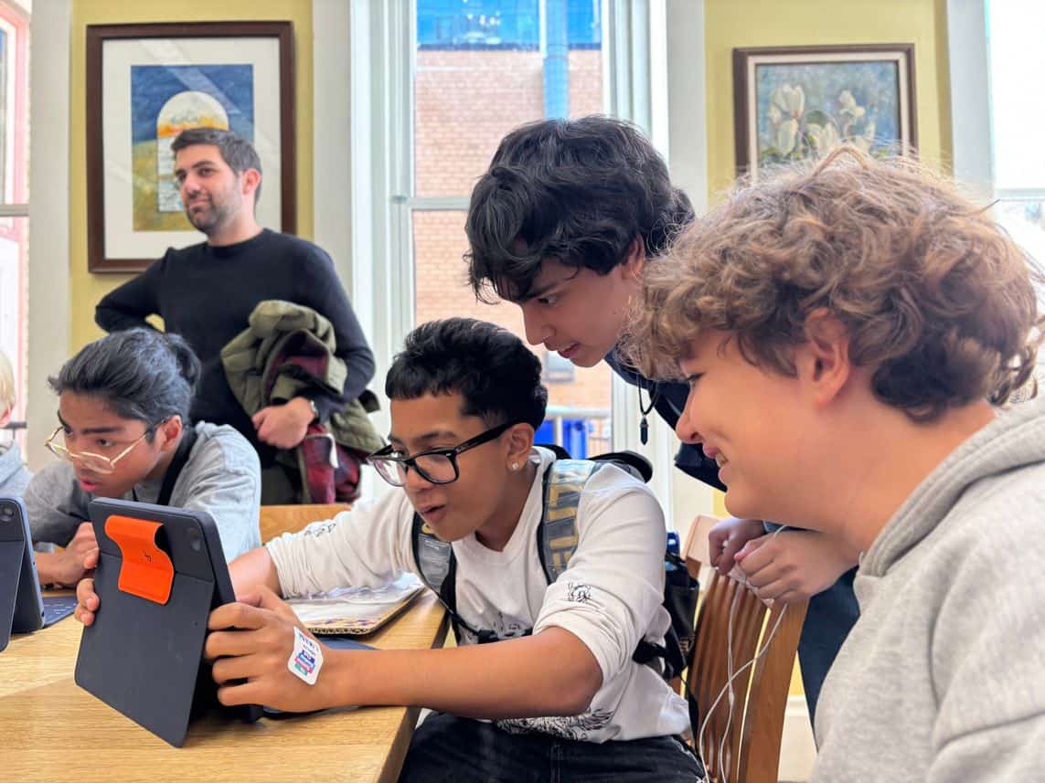 sep2026-newsletter-team-2 Newsletter Team students gathered around a tablet