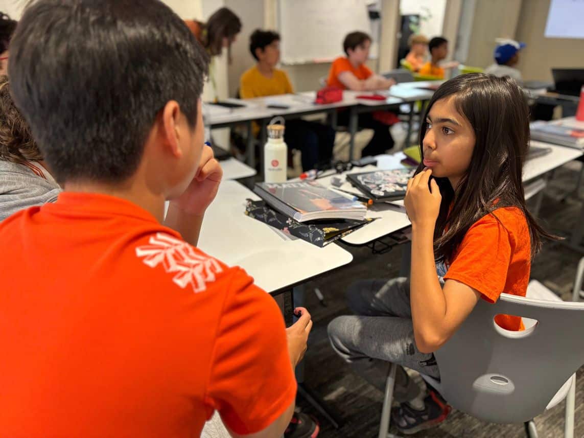 sep2026-orange-shirt-1 Students in orange shirts working in a classroom